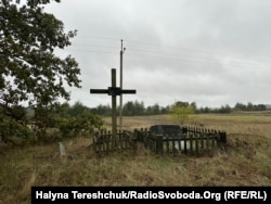 У цьому місці братська могила, де поховані жертви села Угли, яких вбито 12 травня 1943 року