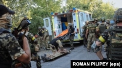 Українські бійці рятують товариша, пораненого під час бою з російськими гібридними силами поблизу Іловайська, 10 серпня 2014 року
