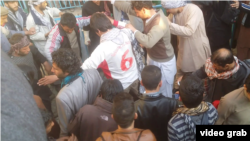 A screen grab of a mob surrounding and attacking a woman who allegedly burned a Koran.