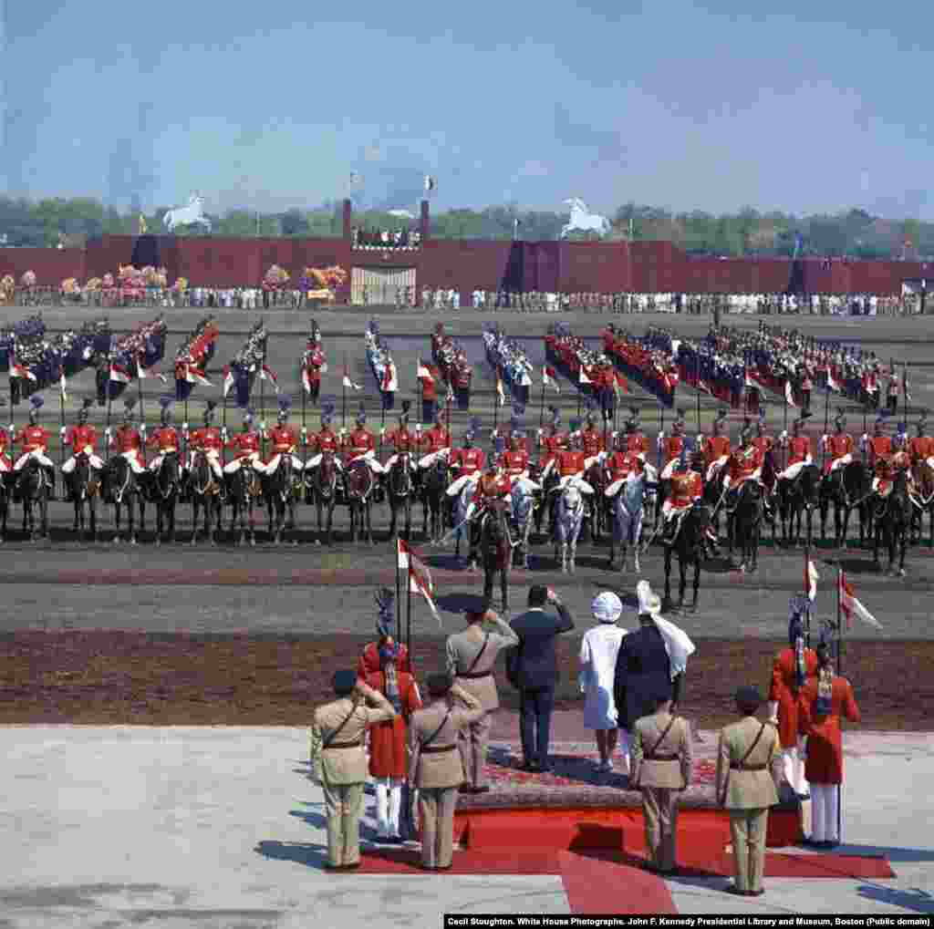 The first lady, in white coat and hat, watches the parade at a horse and cattle fair in Lahore on her first full day in Pakistan.