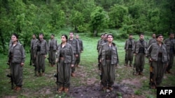 Kurdistan Workers' Party (PKK) members stand at attention after arriving in the northern Iraqi city of Dohuk on May 14.