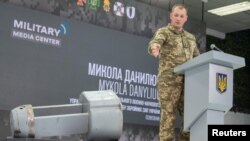 Colonelul Nikola Daniliuk prezintă unul din focoasele oarbe atașate rachetelor de croazieră strategice Kh-55SM lansate recent de armata rusă contra Ucrainei, Kiev, 1 decembrie 2022. 