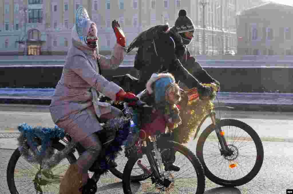 Wrapped in warm clothes, a cyclist takes her pet dog on a winter bike parade in Moscow. (epa/Sergei Chirikov)