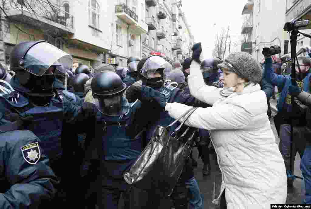 Женщина атакует полицейских, которые пытаются освободить дорогу для проезда микроавтобуса, в салоне которого находится Саакашвили.