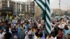 Supporters of the Pakistani Jamaat-e-Islami party carry flags and signs at a rally in support of Kashmir on August 6.