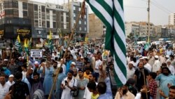 Supporters of the Pakistani Jamaat-e-Islami party carry flags and signs at a rally in support of Kashmir on August 6.