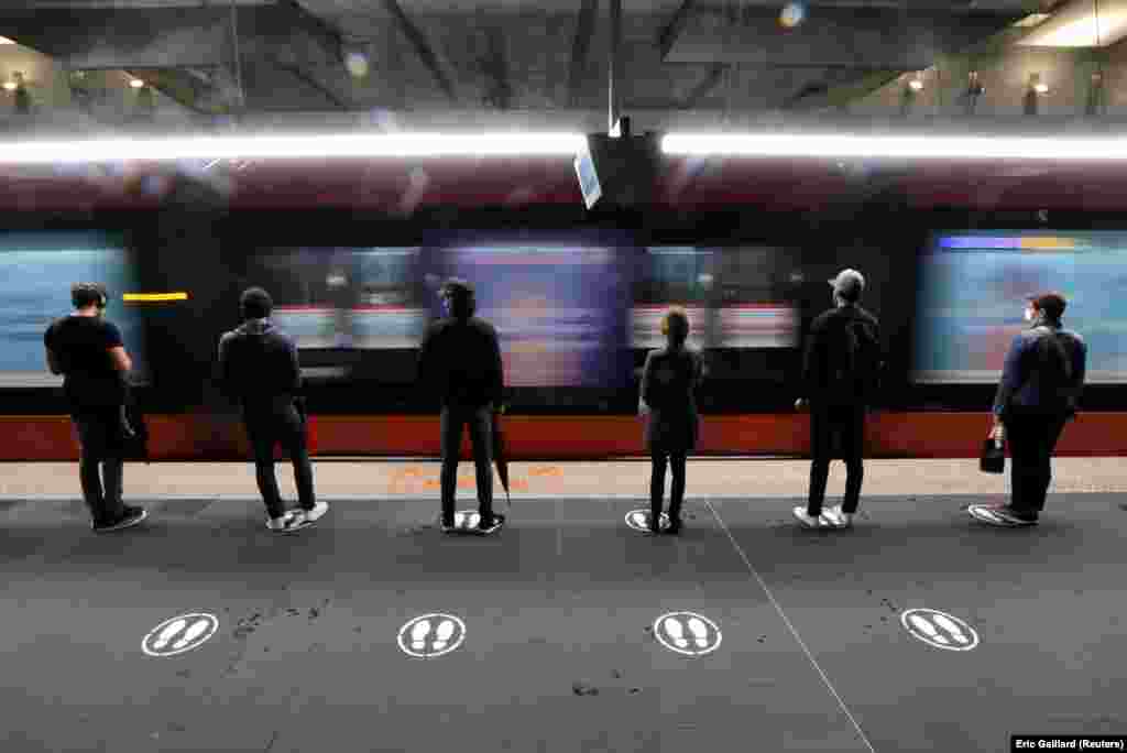 Люди стоять на знаках потреби фізичного дистанціювання на трамвайній зупинці в Ніцці, Франція. (Reuters/Eric Gaillard)&nbsp;