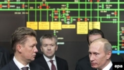 Russian Prime Minister Vladimir Putin (right) speaks with the head of Gazprom, Aleksei Miller (left), at Gazprom headquarters in Moscow on January 13.