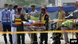Pakistani security officials collect evidence from the scene of a suicide bomb attack on a census team in Lahore on April 5.