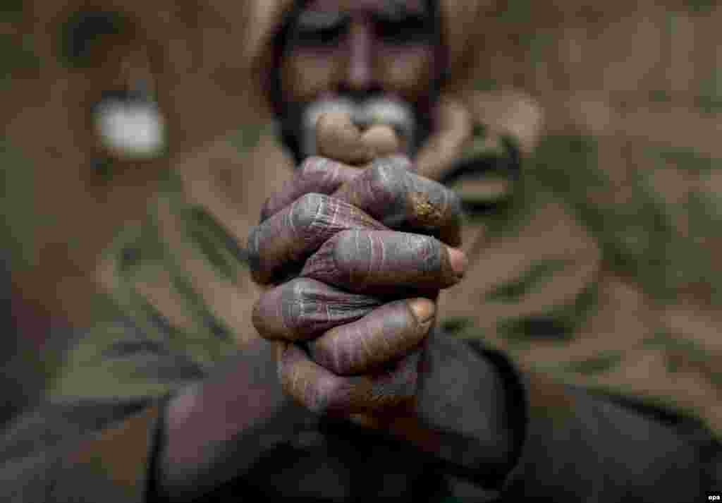 An elderly migrant worker from India warms himself by a fire at a brick factory in Lalitpur, Nepal. Indian and Nepalese seasonal migrant laborers started to arrive at brick factories around the Kathmandu valley with the beginning of the winter season. (epa/Narendra Shrestha)