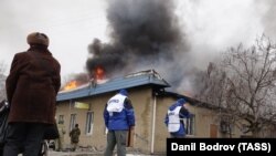 Сотрудники миссии ОБСЕ на месте обстрела одного из жилых районов города Мариуполя. 24 января 2015 года.