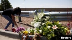 US - A woman places flowers at the site of a mass shooting where 20 people lost their lives at a Walmart in El Paso, Texas, U.S. August 4, 2019.