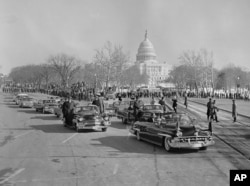 Kolona vozila predsjednika Johna F. Kennedyja (bez šešira u prvom automobilu) izlazi na Aveniju Pennsylvania nakon njegove inauguracije 20. januara 1961. godine. Kennedy je ubijen u novembru 1963. godine.