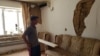 Житель Арыси Нуркен Кокенов осматривает последствия взрывов в своем доме. 28 июня 2019 года.