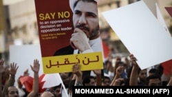 Bahraini protesters hold placard portraying Sheikh Ali Salman, head of the Shiite opposition movement Al-Wefaq, during a demonstration against his arrest on June 16, 2015