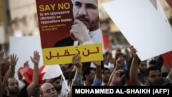 شیعیان معترض بحرینی، تصویری از رهبر خود، شیخ علی سلمان را بر دست دارند