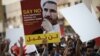 Bahraini protesters hold a placard portraying Sheikh Ali Salman, head of the Shiite opposition movement Al-Wefaq. File photo