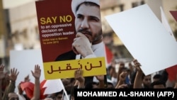 Bahraini protesters hold a placard portraying Sheikh Ali Salman, head of the Shiite opposition movement Al-Wefaq. File photo