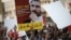 Bahraini protesters hold placard portraying Sheikh Ali Salman, head of the Shiite opposition movement Al-Wefaq, during a demonstration against his arrest on June 16, 2015