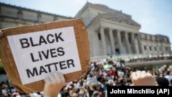Több államban már eddig is megemlékeztek a napról. Tüntető Black Lives Matter-táblával a Brooklyn Múzeum előtt, 2020. június 19.