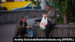 Чоловіки на вокзалі щойно отримали новий довідник із адресами й контактами місць, куди може звернутися бездомна людина