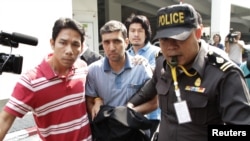 Thai police officers escort Iranian bombing suspect Mohammad Khazaei (center) in Bangkok.