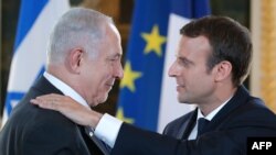 French President Emmanuel Macron (R) and Israeli Prime Minister Benjamin Netanyahu in Paris