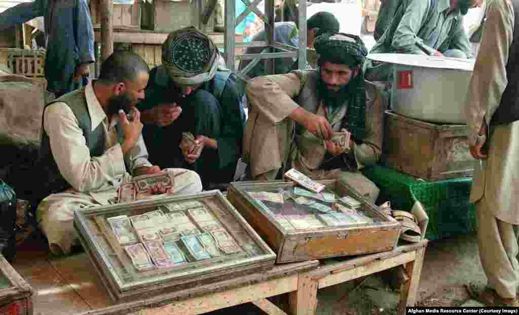 As well as their main task of chronicling the war, the teams of AMRC photographers shot everyday life, like these money changers in Peshawar.