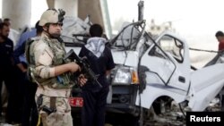 An Iraqi soldier stands guard at the site of a bomb attack in Baghdad's Hussainiya district on May 6.