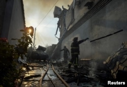 Рятувальники працюють на ділянці приватного будинку, який сильно постраждав від російського обстрілу, під час евакуації місцевих жителів, червень 2023 року