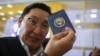 Мужчина показывает новые образцы кыргызского паспорта. Бишкек, Кыргызстан, 30 мая 2021 года
