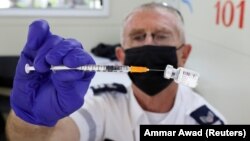 Медицинский работник готовит для введения вакцину против коронавирусной болезни (COVID-19) в мобильном центре вакцинации в Тель-Авиве, Израиль, 6 июля 2021 года
