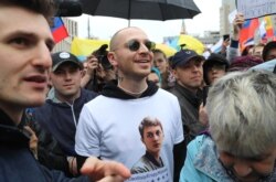 Rapper Oxxxymiron (center) wore a T-shirt in support of Zhukov during a rally in Moscow in August.