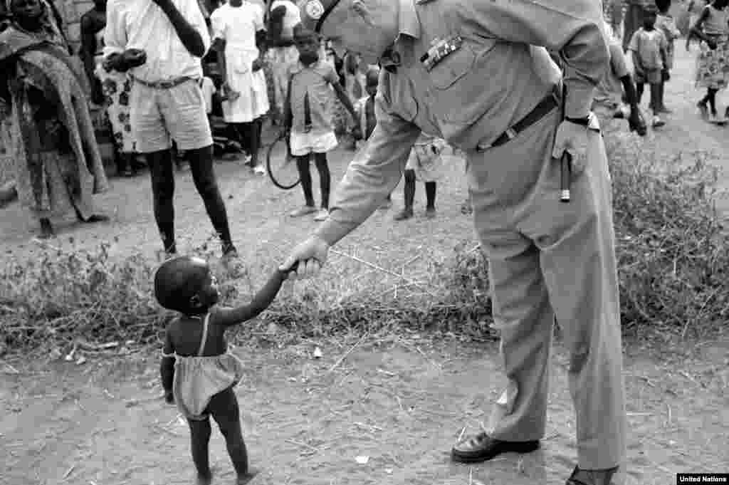 A UN commander in the Congo greets a youngster during his tour of an outpost in 1960. The UN mission there continued until 1964, during which time it evolved from being&nbsp;a peacekeeping presence into a military force.