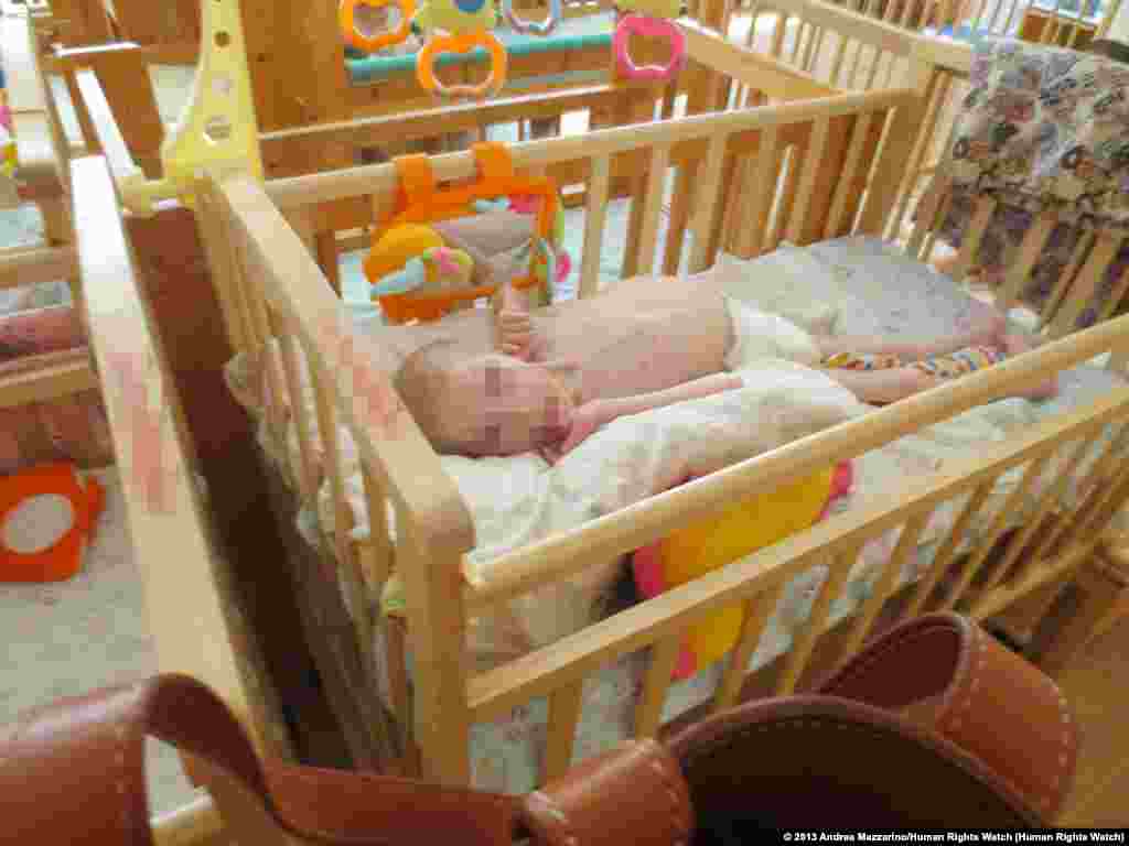 Sveta L., a 13-year-old girl in her crib in a &quot;lying-down&quot; room of an orphanage for children with disabilities in northwest Russia.