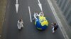 Demonstruesit rrotullojnë një glob gjigand nëpër një rrugë ndërsa marrin pjesë në një protestë për klimën. Foto nga arkivi. 