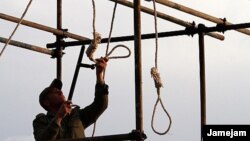Un bărbat din Iran pregătește un ștreang cu care urmează să fie spâzurat un condamnat la moarte. 