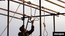 A soldier prepares a noose ahead of a public hanging.