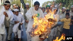 Pakistani protesters burn an effigy of U.S. President Barack Obama as they protest against Facebook in Lahore on May 26.