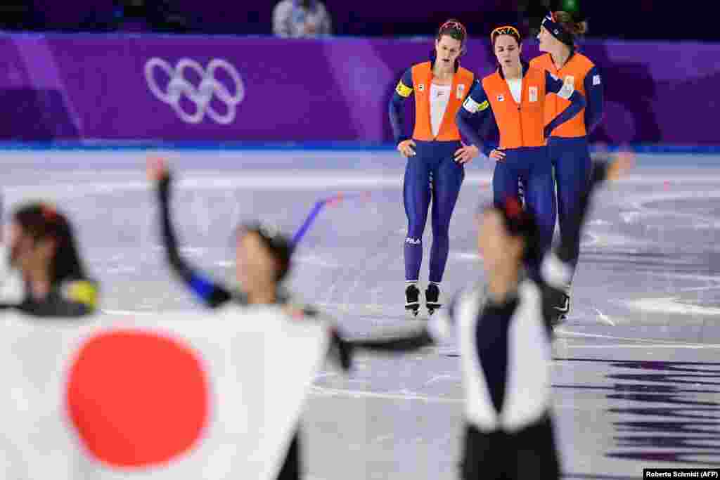 Ковзанярський спортю Зліва на право: спорстменки з Нідерландів Ірен Вюст, Марріт Ленстра та Антуанетте де Йонг реагують на срібло, а японська команда (на передньому плані) святкує золото у фіналі жіночої командної гонки