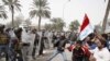 Riot policemen disperse protesters during a demonstration in Basra on March 4.