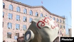 Armenia -- An enviromental activist wears a gas mask outside the Administative Court in protest against a controversial mining project, 23 March 2010.