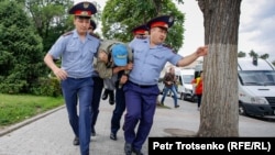 Полиция алаңға келгендердің бірін әкетіп барады. Алматы, 10 маусым 2019 жыл.