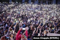 Protesters hold up their phones as Zaza Saralidze speaks to the crowd blocking Rustavel Avenue on June 1.
