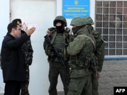 Російські та українські військові біля входу до української військової частини у Севастополі