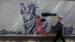 A man walks near an anti-US mural in Tehran on June 30.