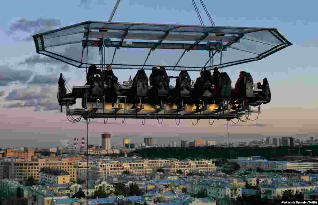 Diners sit around a Sky Table suspended 50 meters in the air by crane as part of the Dining In The Sky experience in Moscow.
