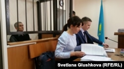 Teimur Akhmedov (left), in the defendant's cage, and his lawyers in an Astana courtroom on March 27.