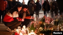 Өрттен қаза тапқандарды еске алып, гүл мен шырақ қойып жатқан адамдар. Кран-Монтана, Швейцария, 3 қаңтар, 2026 жыл.
