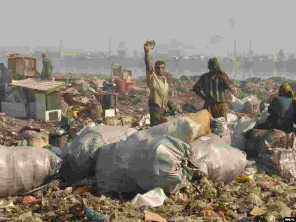 Workers sort through garbage at a dump in Baku - That complaint applies to other sectors as well. The grandiose construction projects have done nothing to improve the economic status of most Azerbaijanis. And while new hotels and entertainment complexes sprout in downtown Baku, other parts of the capital remain devastated by the environmental impact of the oil industry. 